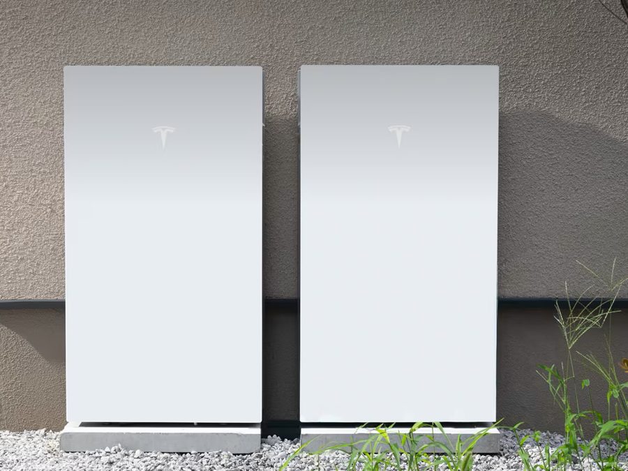 住宅の外壁に沿って設置された Tesla Powerwall 3 の本体